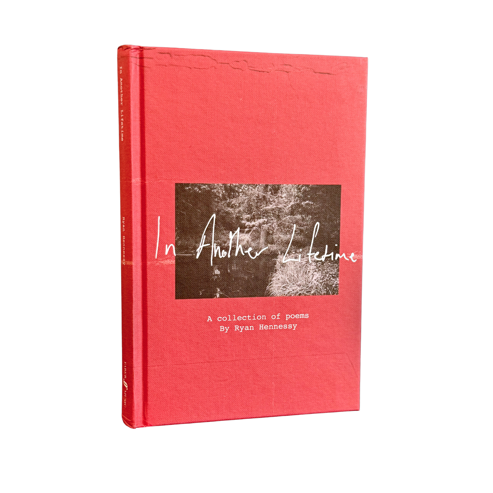 A hardcover book titled 'In Another Lifetime: A collection of poems' by Ryan Hennessy, featuring a textured coral-red cover with a central square black-and-white photograph and white script text.